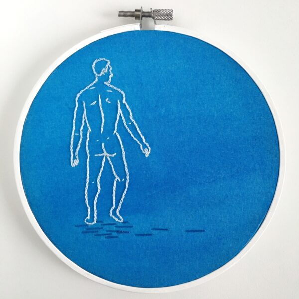 An embroidered piece of a male figure in a white line on a blue background.